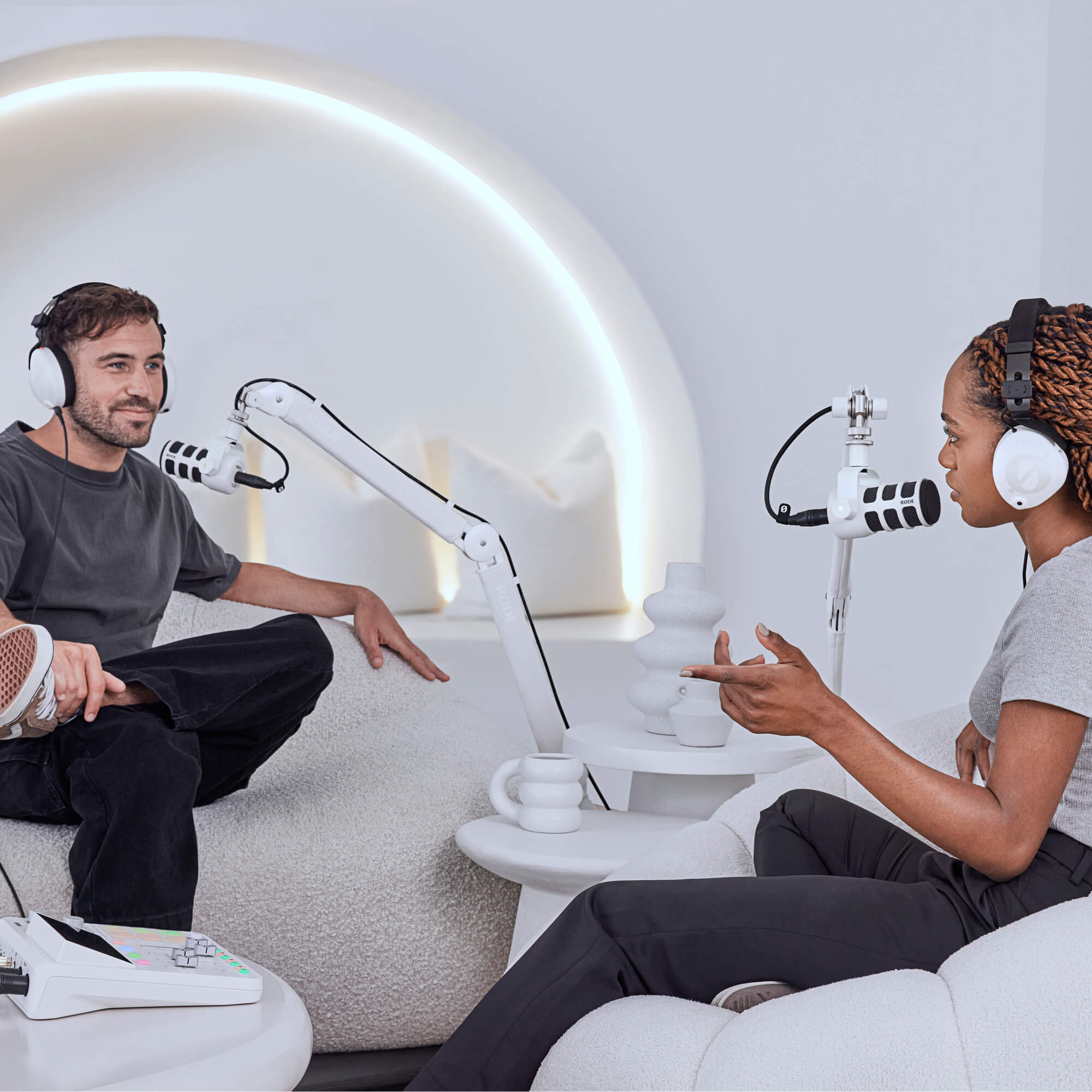 Bela roka RØDE PSA1+ in beli PodMic v svetlem podcast studiu